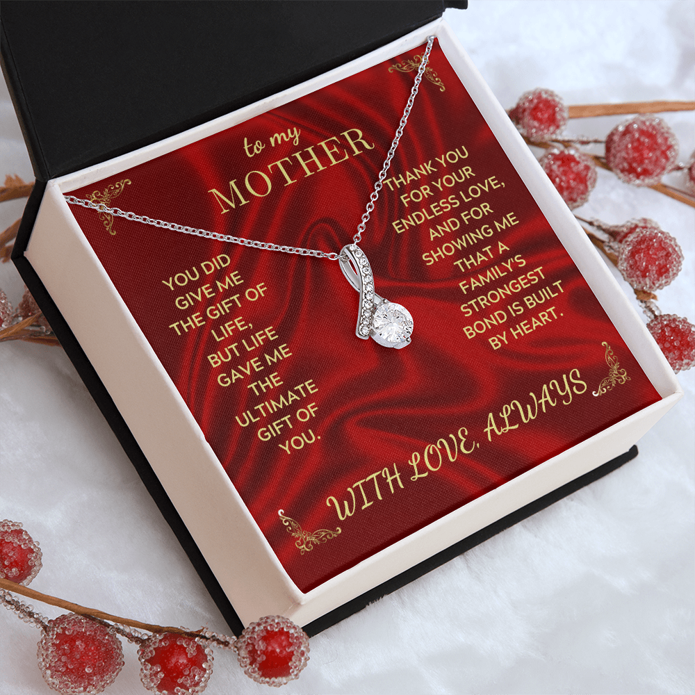 Gold-tone necklace with teardrop crystal heart pendant in open red gift box