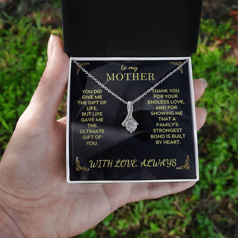 Silver-tone teardrop pendant necklace on black gift card, shown in an open box