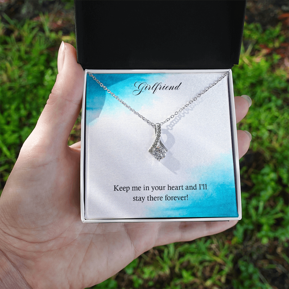 Silver-tone heart teardrop pendant necklace resting in an open gift box.