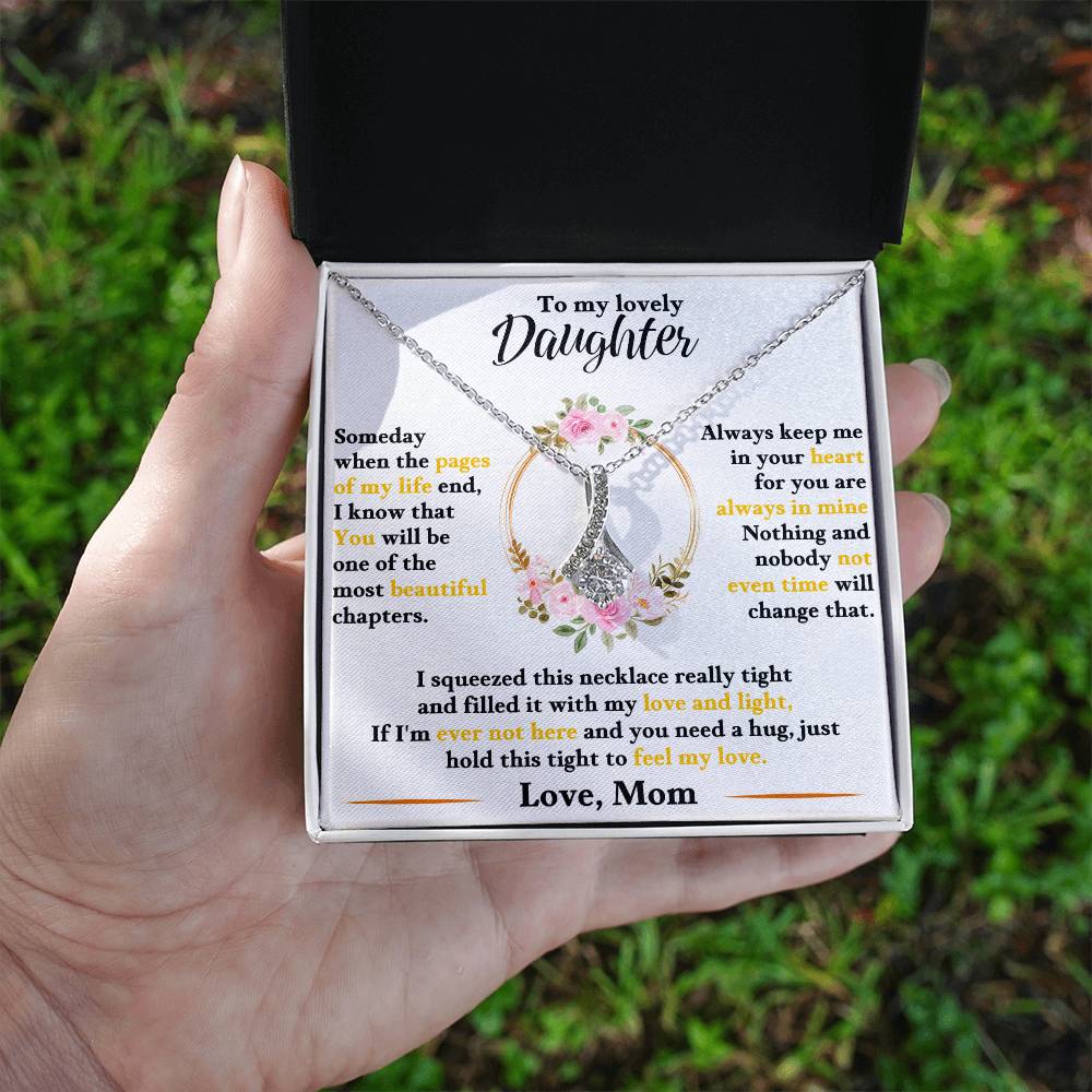 Daughter keepsake necklace held in hand, silver-tone chain and heart charm inside white box