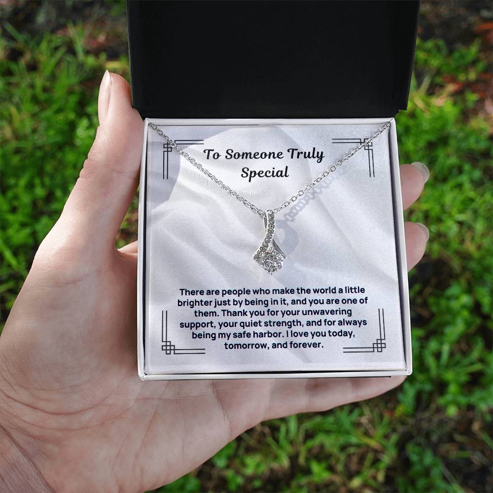 Silver-tone necklace with teardrop crystal pendant, shown in a gift box