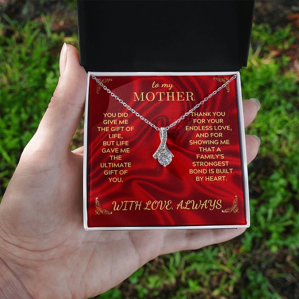 Silver-tone necklace in hand on red gift card, teardrop crystal heart pendant