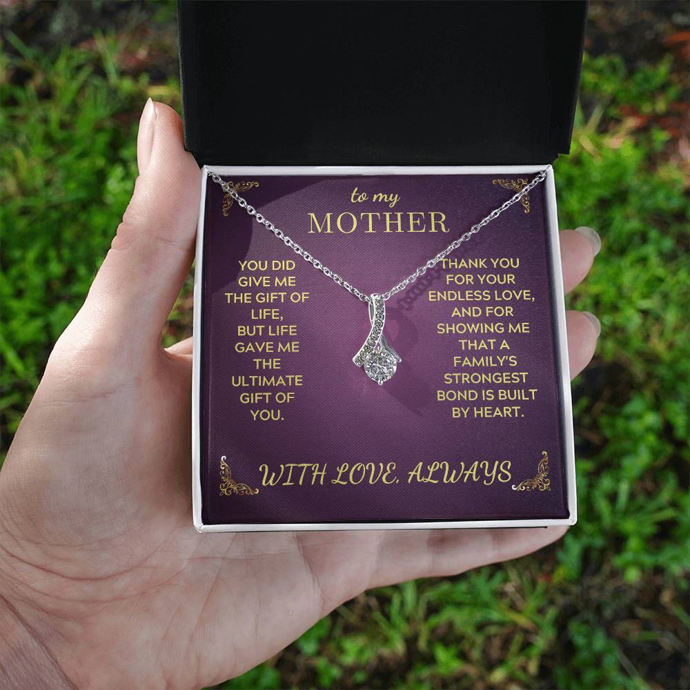 Silver-tone Mother necklace with heart teardrop pendant on purple gift box in hand