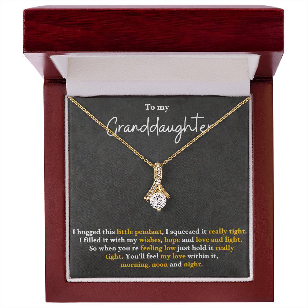 Gold-tone pendant necklace inside a red wood-style gift box, featuring a teardrop charm.