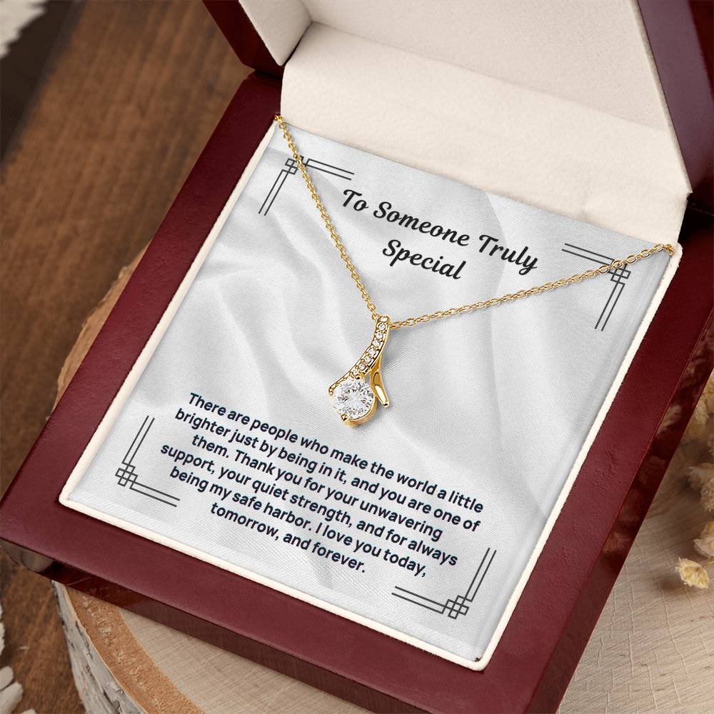 Gold tone pendant necklace draped over “To Someone Truly Special” message card