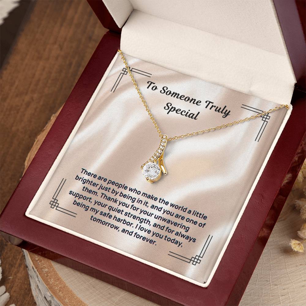 Gold-tone stone pendant necklace with clear pendant in red box and card