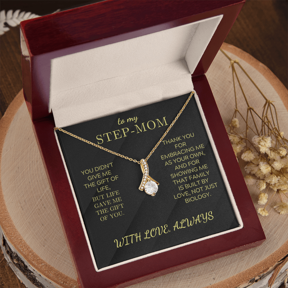 Gold-toned necklace with teardrop pendant and clear stones, in open gift box