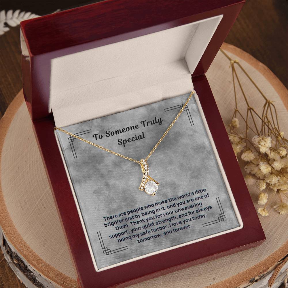 Gold-tone necklace with teardrop pendant, shown in open luxury red gift box