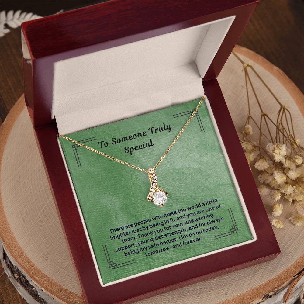 Green message necklace with gold-tone chain and teardrop pendant, shown in open box