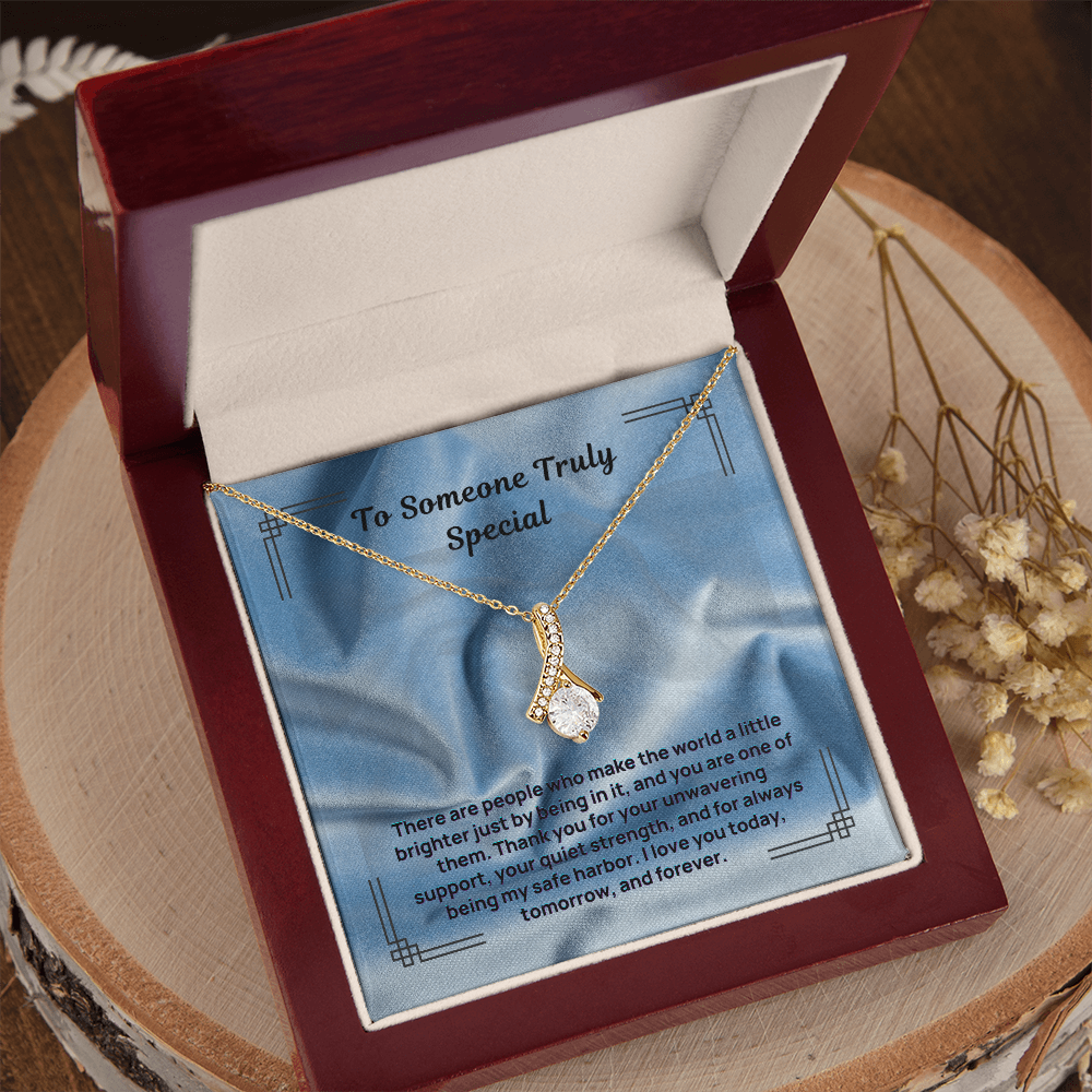 Gold-tone teardrop pendant necklace on blue message card inside red gift box