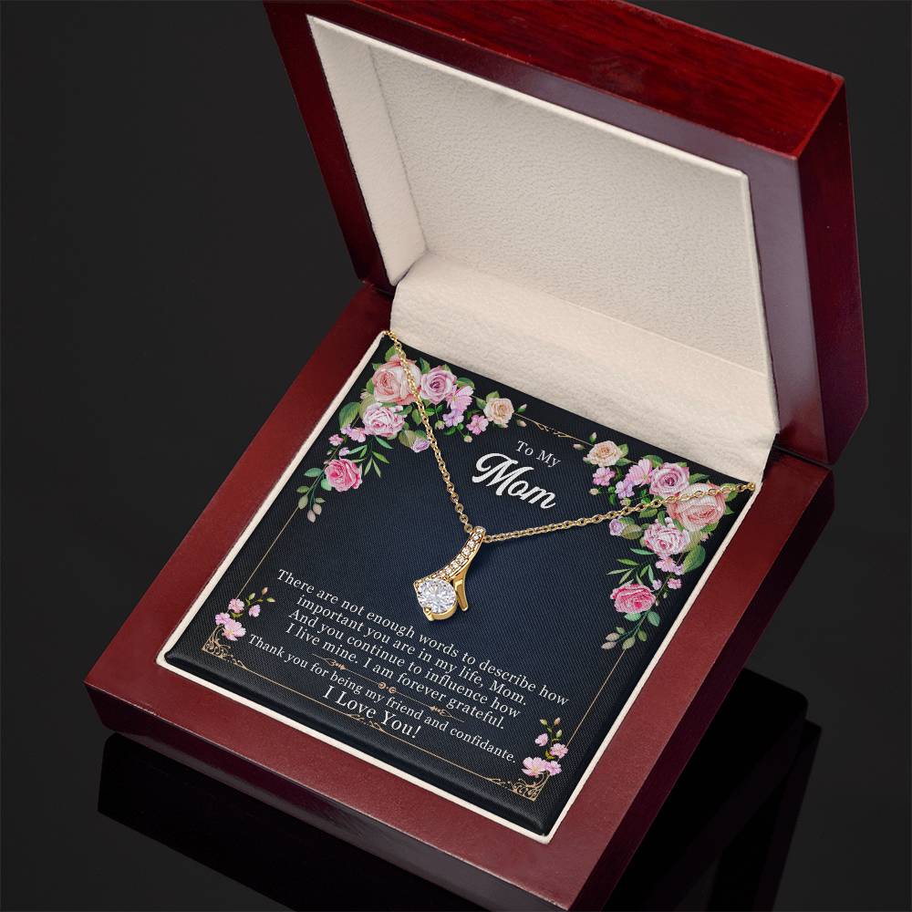 Gold-tone mom pendant necklace resting in open red gift box