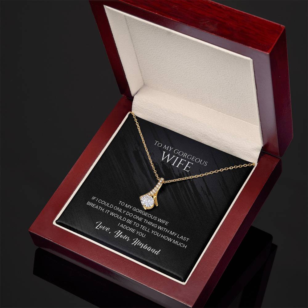 Gold-tone wife pendant necklace with teardrop crystal charm, open red gift box