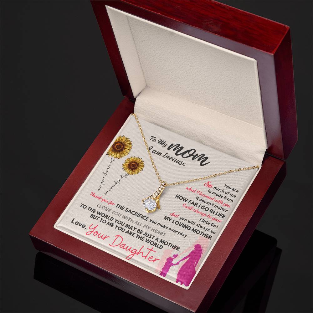 Gold-tone necklace with teardrop pendant in red wooden gift box, angled view