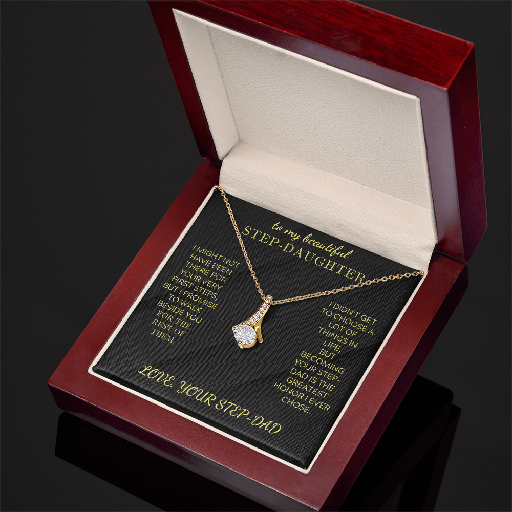 Gold-tone teardrop crystal pendant necklace in open red jewelry box.