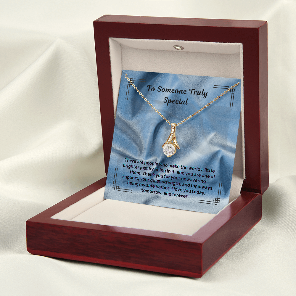 Gold-tone teardrop pendant necklace shown on blue message card in opened red box