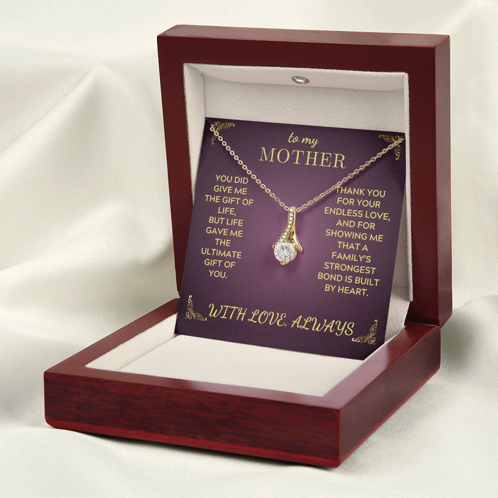 Open jewelry gift box with gold-tone necklace and teardrop crystal pendant on purple insert