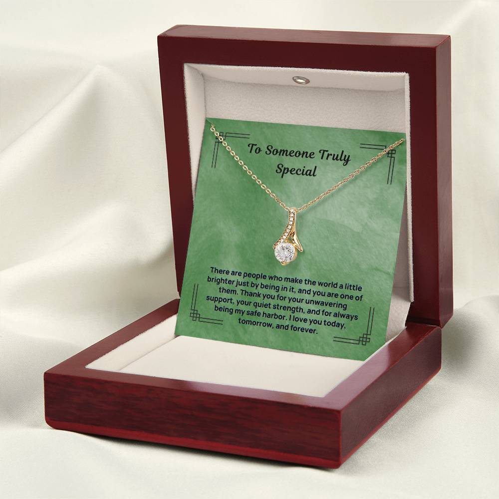 Green message necklace with gold-tone chain and teardrop pendant in open stand display box