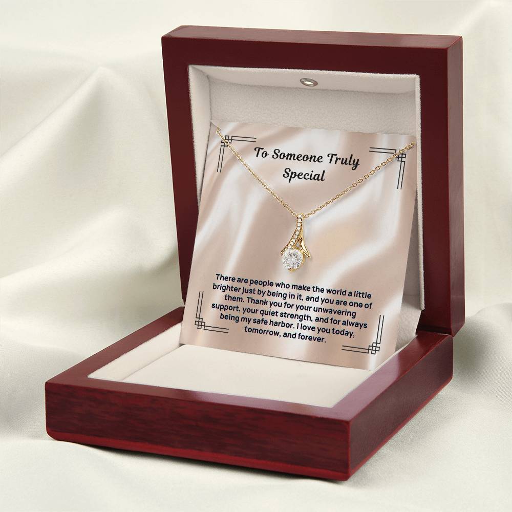 Gold-tone stone pendant necklace in red open gift box with white display