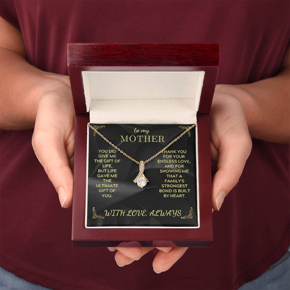 Gold-tone mother necklace gift box held in hands with black message card