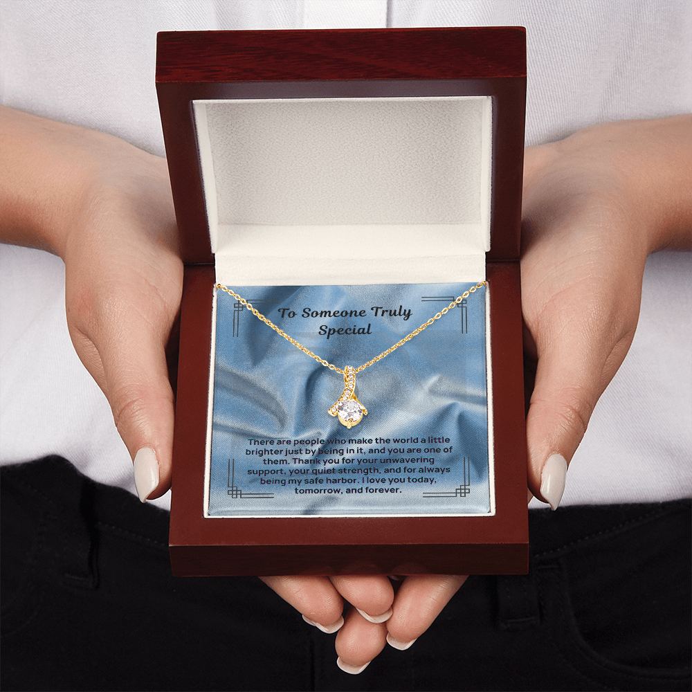 Gold-tone teardrop pendant necklace displayed on blue message card in box