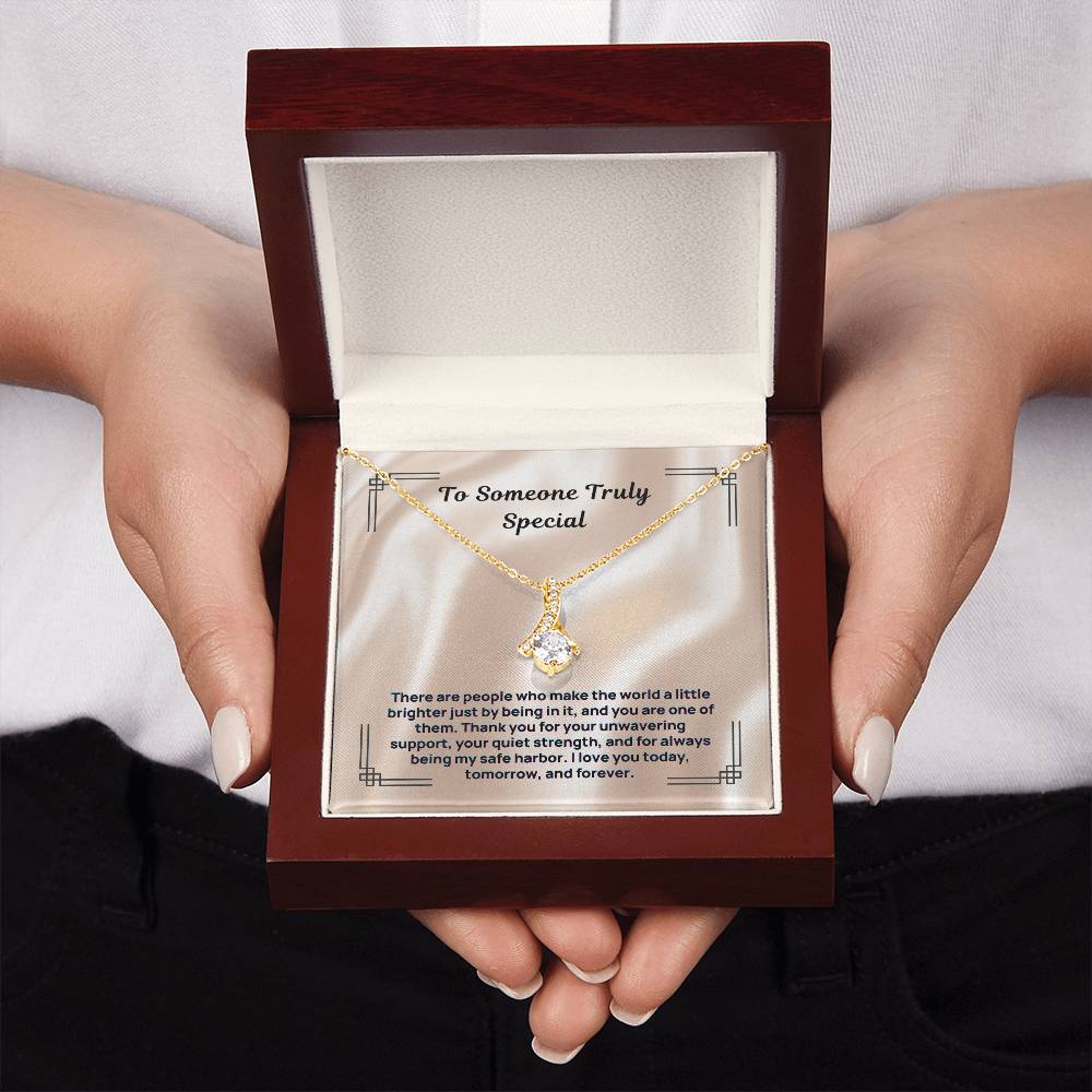 Gold-tone stone pendant necklace in red gift box held in hands