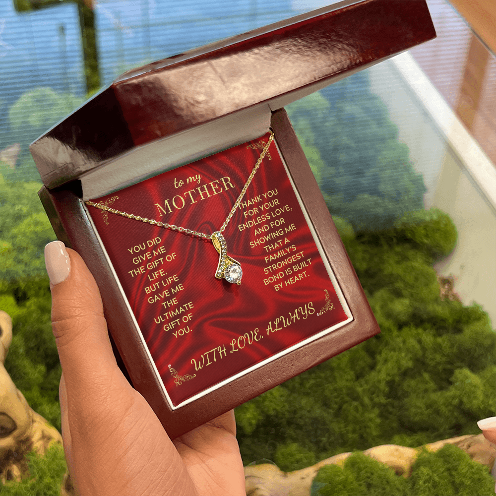 Necklace gift box held outdoors, red card 'To my Mother' with gold-tone teardrop pendant