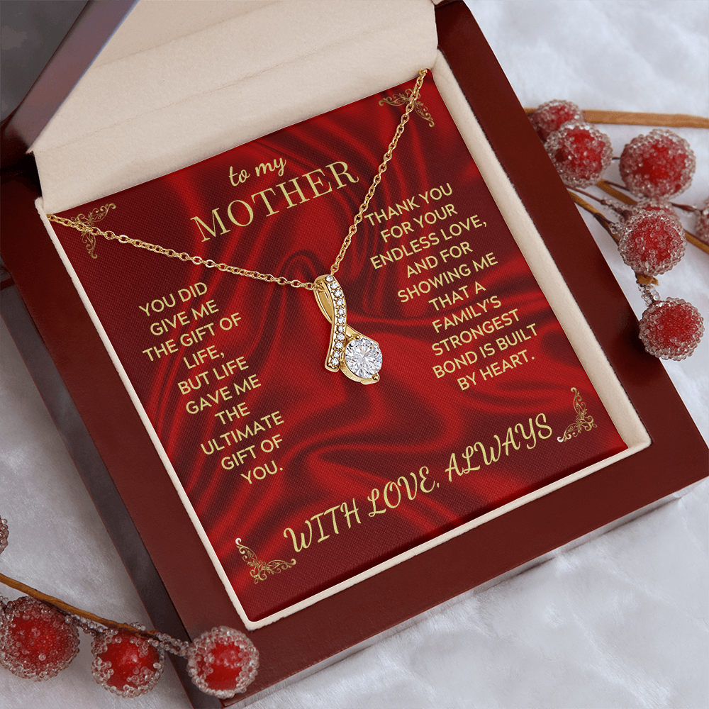 Open necklace gift box showing gold-tone chain and teardrop crystal pendant on red card