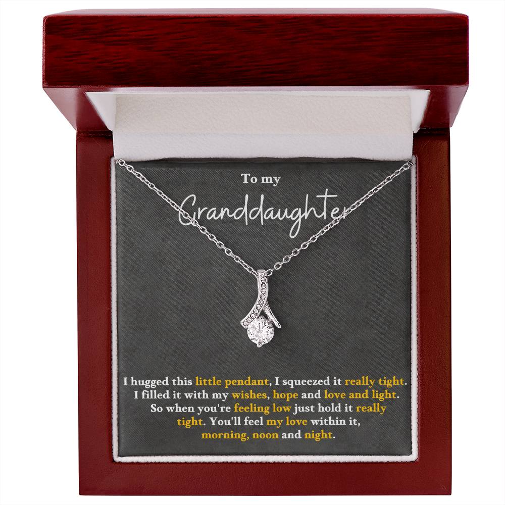 Silver-tone pendant necklace inside a red wood-style gift box, with teardrop charm.