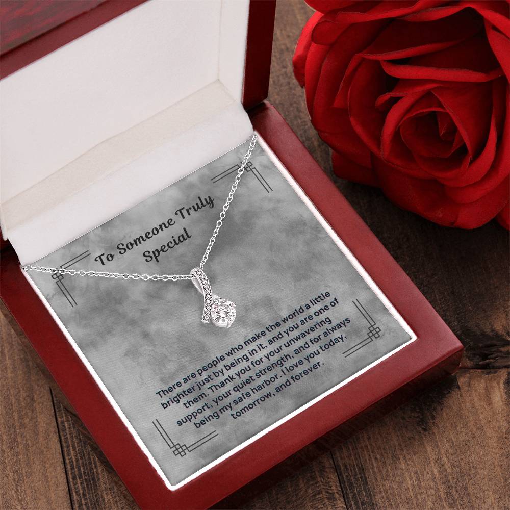 Silver-tone teardrop crystal pendant necklace resting in a red gift box