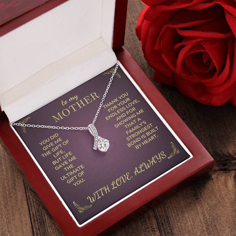 Silver-tone teardrop pendant necklace in a purple gift box with decorative text