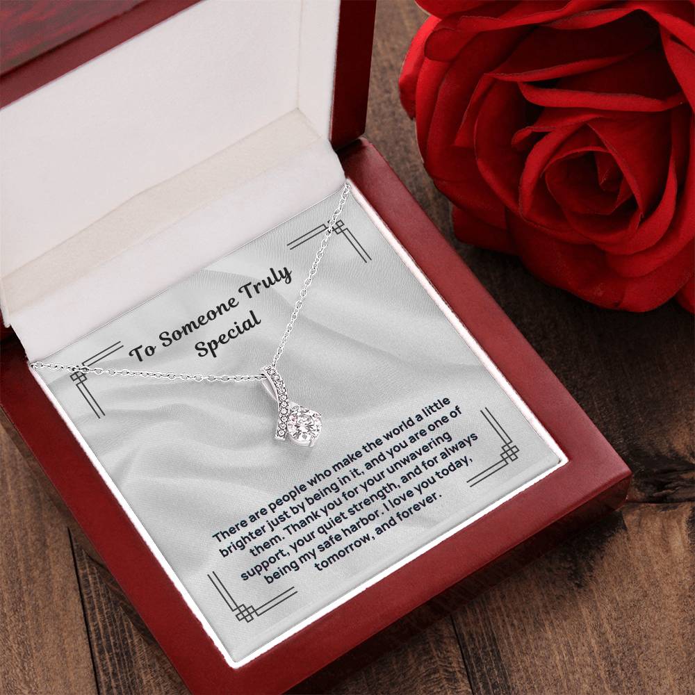 Silver-tone necklace with teardrop crystal pendant in open jewelry box