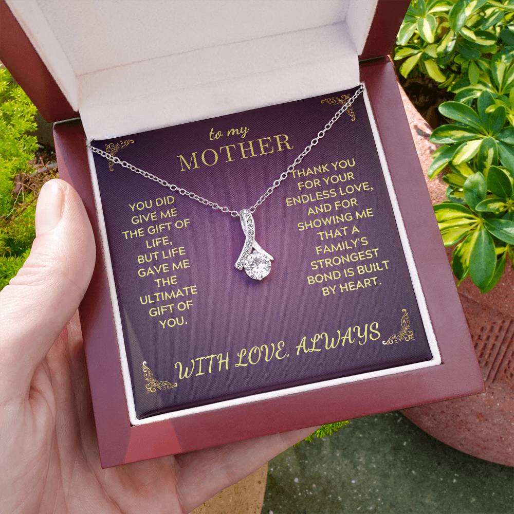 Silver-tone pendant necklace displayed on a purple keepsake card in a gift box