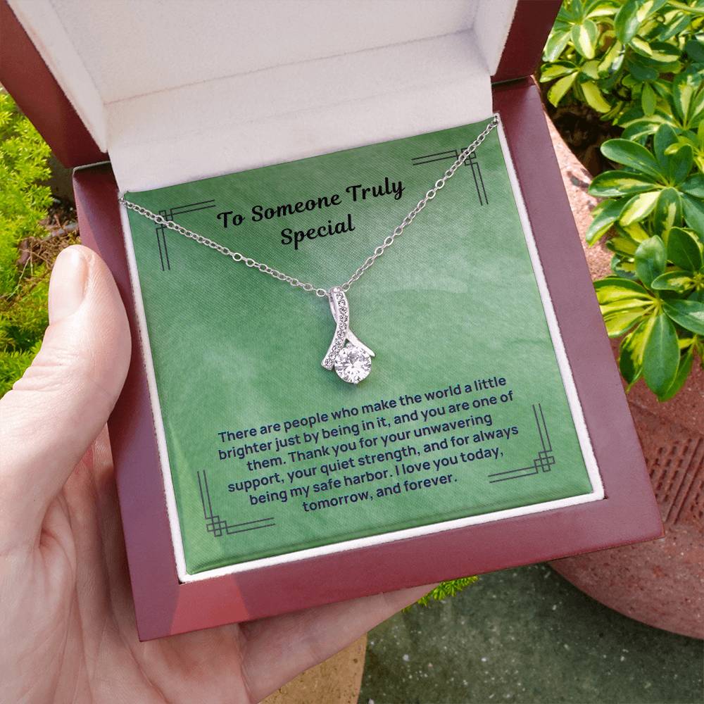Silver-tone teardrop pendant necklace in an open gift box held in hand