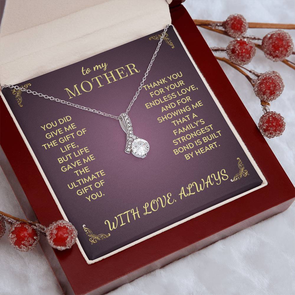 Silver-tone teardrop pendant necklace on a purple keepsake card in a red gift box