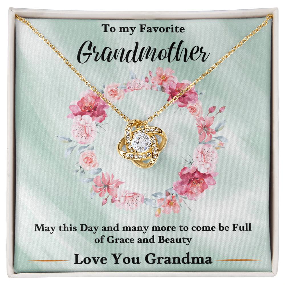 Gold heart love knot pendant necklace with rhinestone accents on a floral gift card