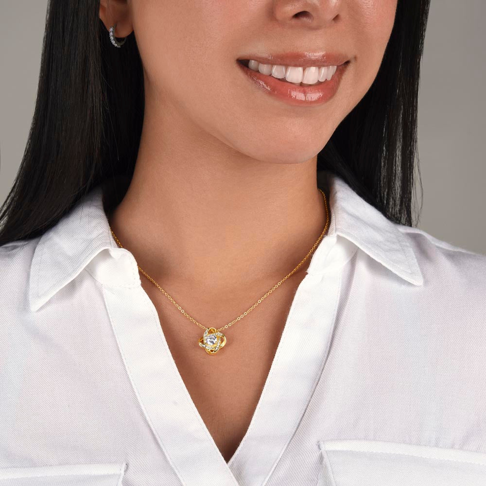 Heart pendant necklace on gold-tone chain over white shirt