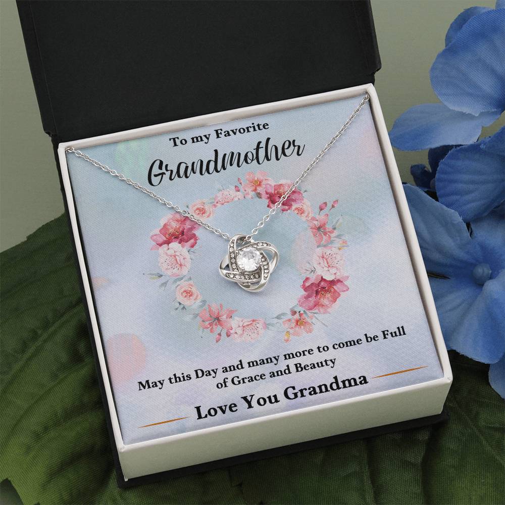 Silver-tone heart love knot necklace pendant with chain, displayed inside a gift box