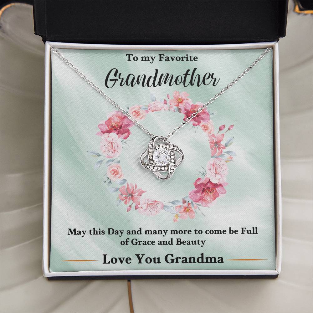 Silver heart-shaped love knot pendant necklace on a floral gift card in a box