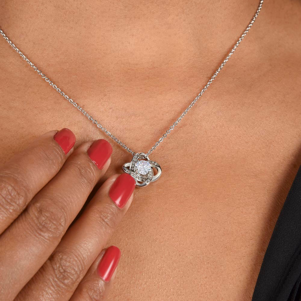 Love knot heart pendant necklace with clear-stone knot, silver chain close-up
