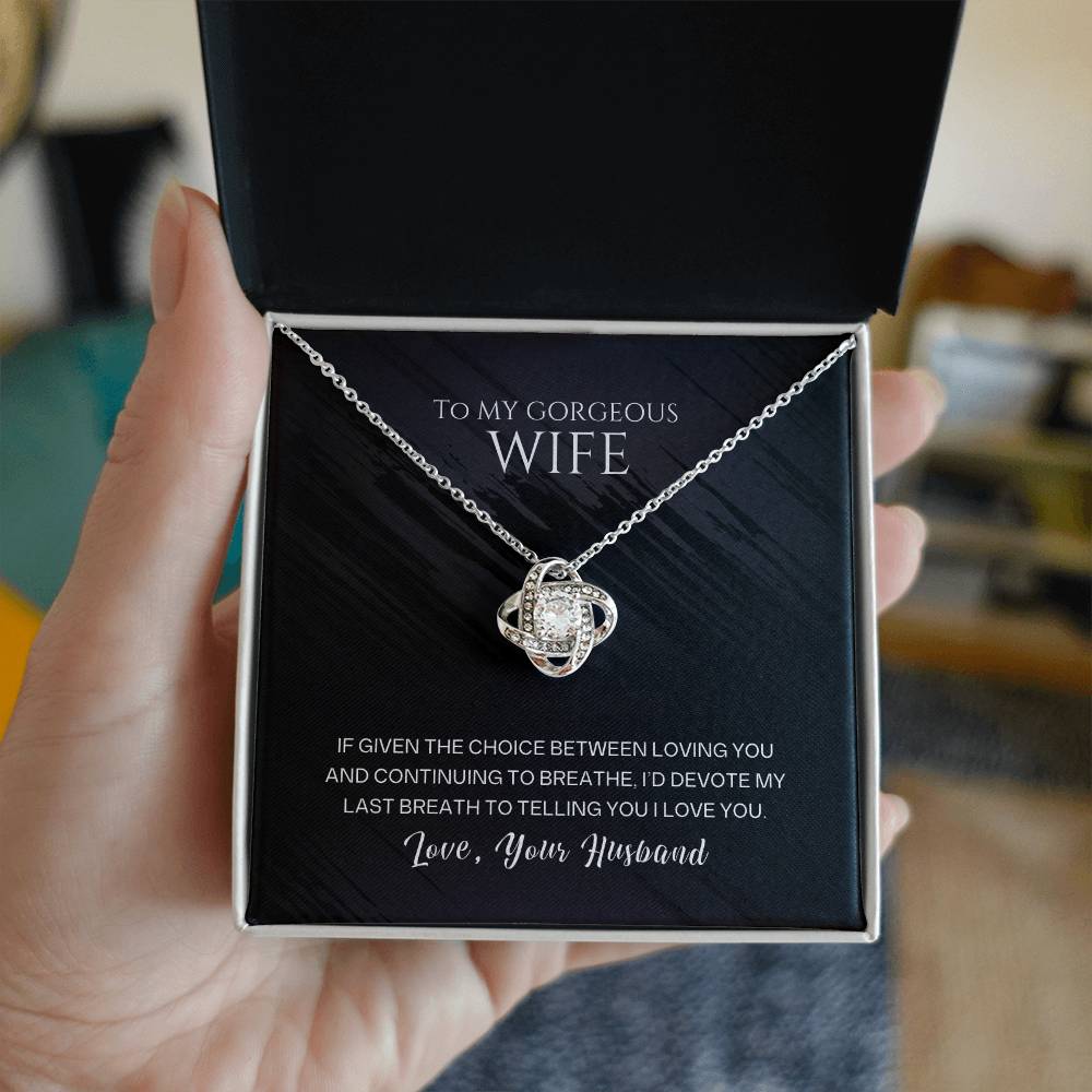 Silver-tone heart pendant necklace with pave stones, held above gift box
