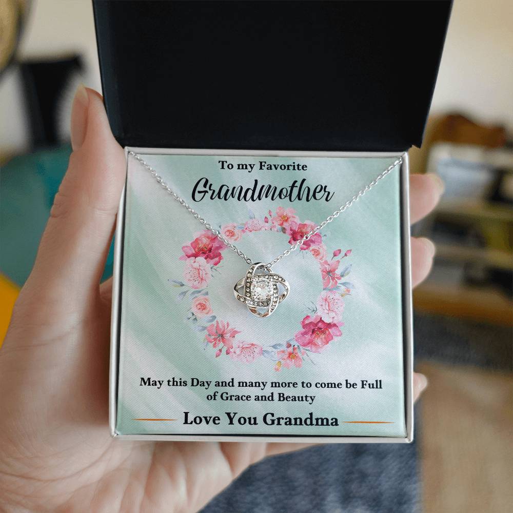 Silver love-knot heart pendant necklace with chain, shown in a gift box
