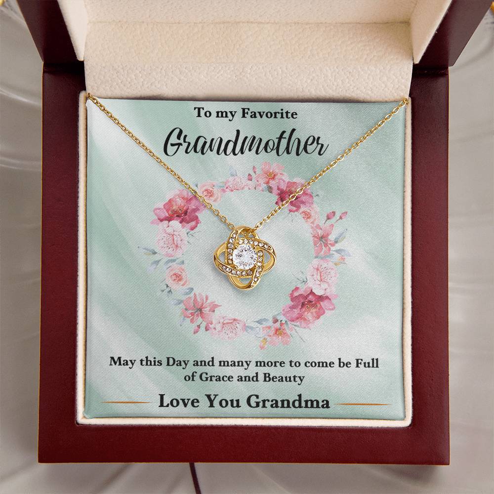 Gold heart-shaped love knot necklace with rhinestone pendant in a gift box