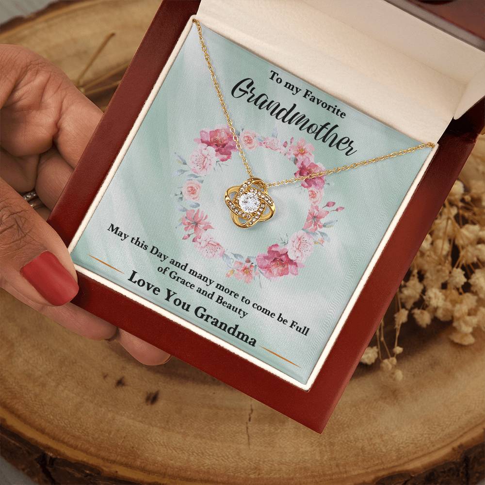 Gold heart love knot necklace with rhinestone pendant in an open gift box