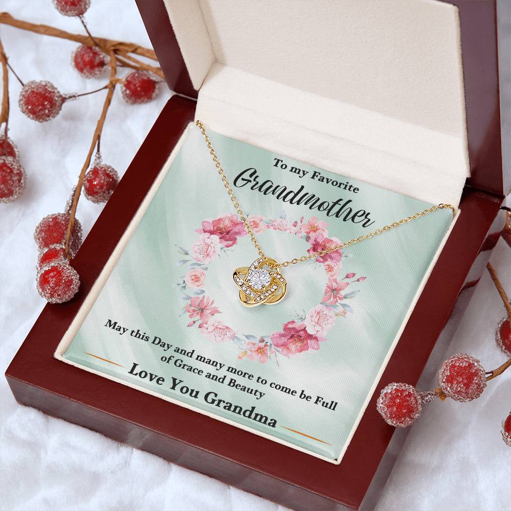 Gold love-knot heart pendant necklace with chain, displayed in an open gift box