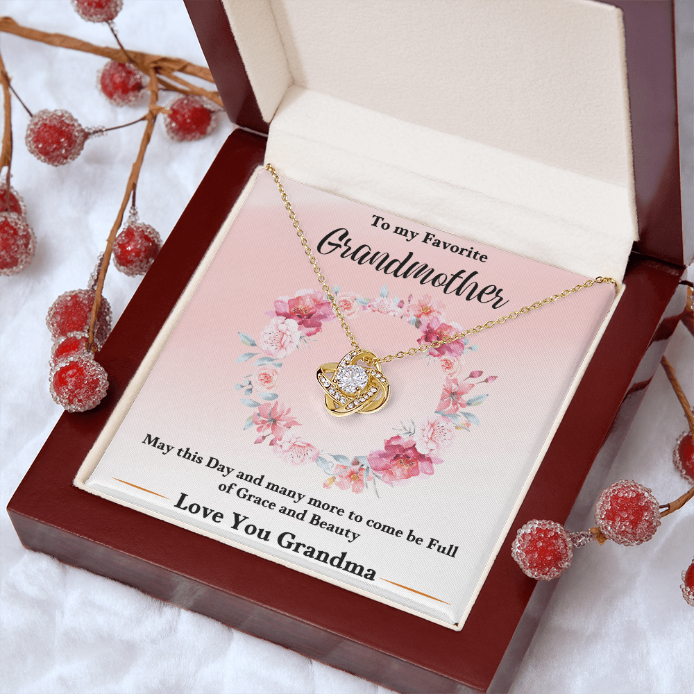 Gold love-knot pendant necklace in pink floral keepsake box on red gift tray