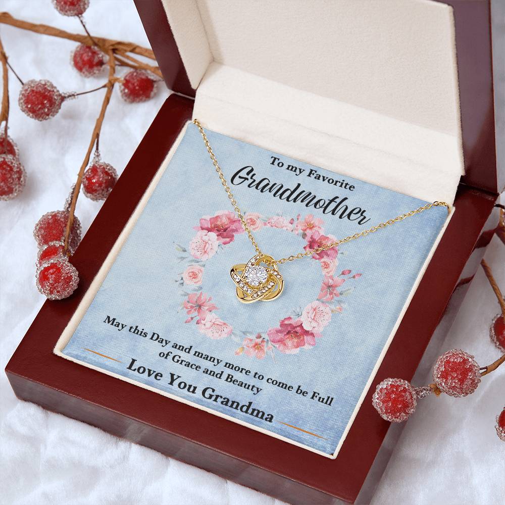 Gold-tone love knot heart pendant necklace in a blue gift card on red box
