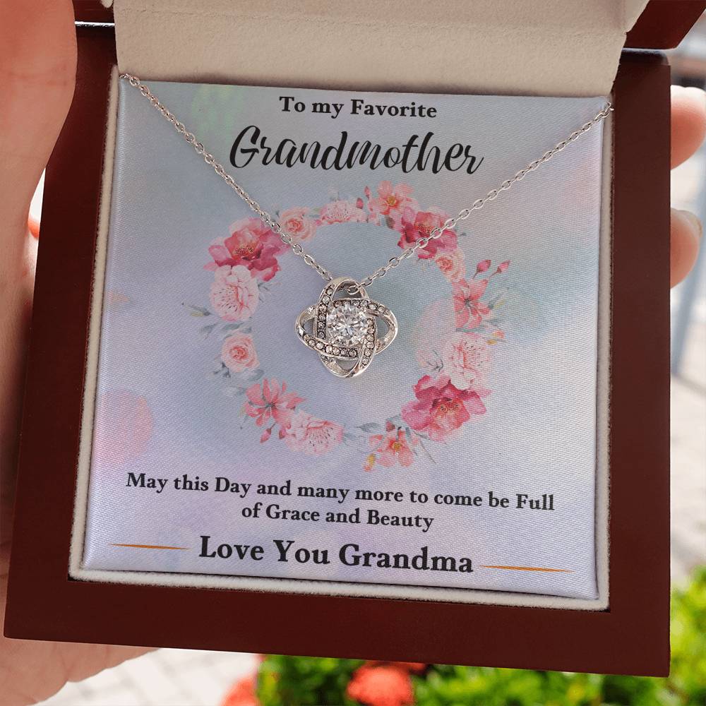 Silver heart knot pendant necklace displayed in a gift box