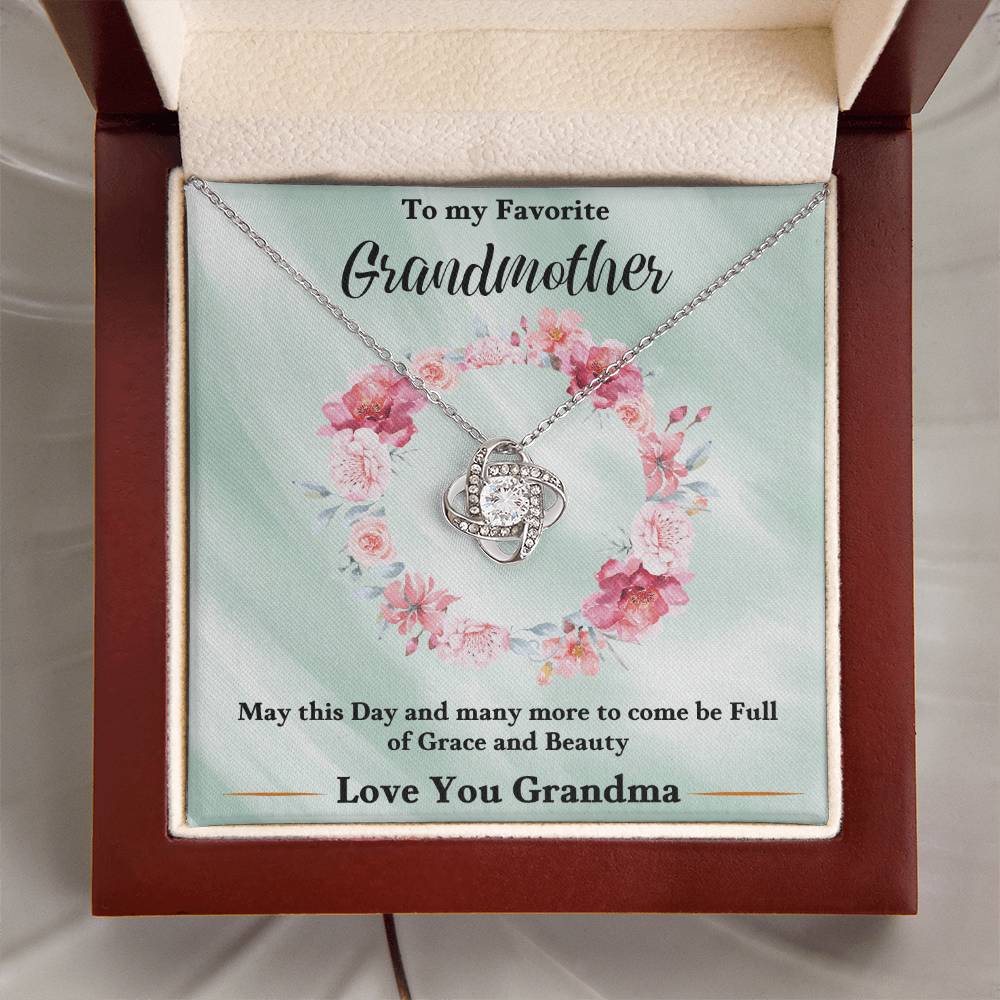 Silver heart love knot necklace with rhinestone pendant on a gift card inside a box