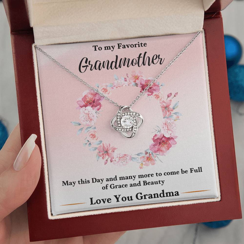 Silver love-knot pendant necklace in pink floral keepsake box, close-up