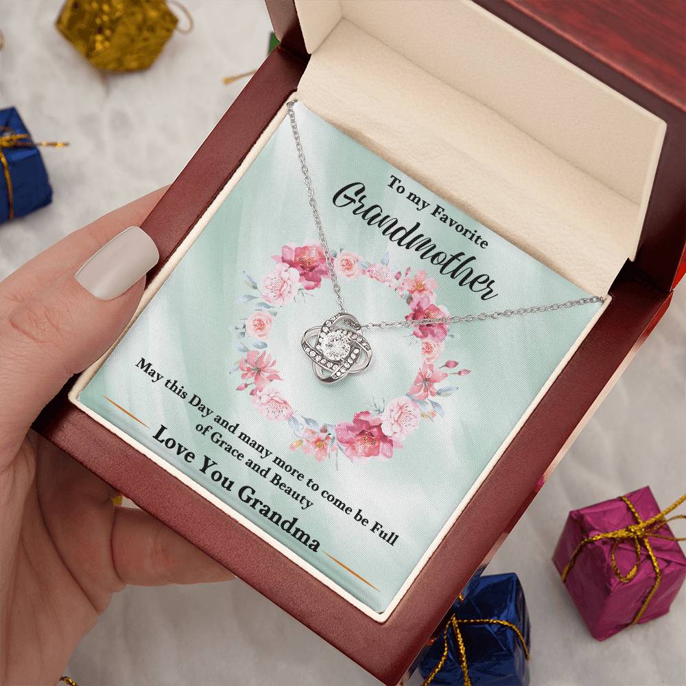 Silver heart love knot necklace with rhinestone pendant shown in an open gift box